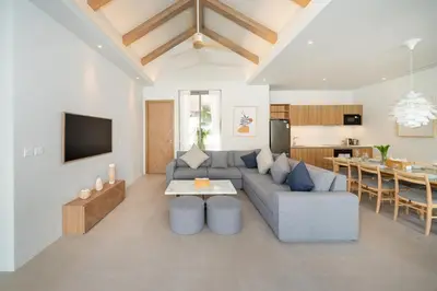 a living room with a couch and a table at Himmapana Villas - Grand Valley in Kamala Beach