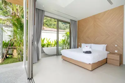 a bedroom with a large bed and a tub at Himmapana Villas - Grand Valley in Kamala Beach