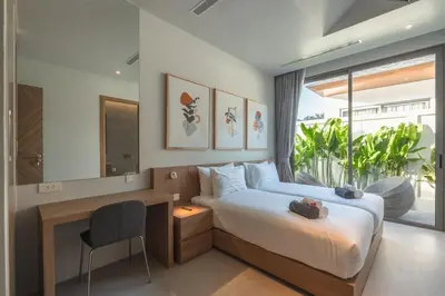 a bedroom with a bed with a desk and a window at V157 Brand New Beautiful Dream Villa in Kamala Beach