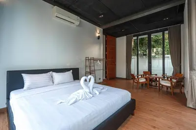 two white swans sitting on a bed in a bedroom at V158 9BR Tennis On prestigious Phuket Country Club in Kathu
