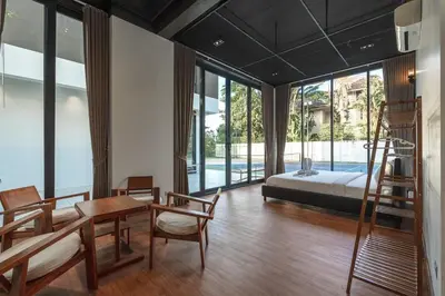 a bedroom with a bed and a table and chairs at V158 9BR Tennis On prestigious Phuket Country Club in Kathu