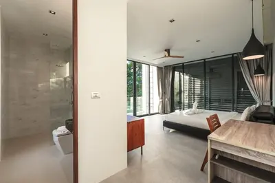 a bedroom with a bed and a desk in a room at V158 9BR Tennis On prestigious Phuket Country Club in Kathu