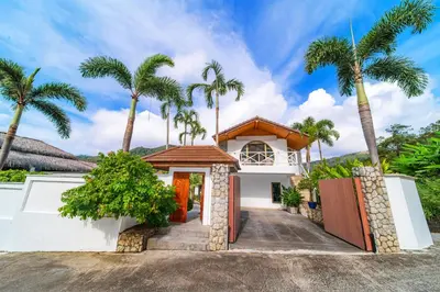 a house with palm trees in front of it at kamala 1000 sqm new luxury 4 bedroom holiday pool villa extra large space amazing sunset in Kamala Beach