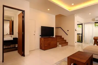 a living room with a flat screen tv on a wooden cabinet at Spacious 3bd Townhouse in Laguna park in Laguna Phuket