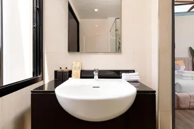 a bathroom with a white sink and a mirror at Spacious 3bd Townhouse in Laguna park in Laguna Phuket