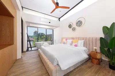 a bedroom with a large bed and a couch at Spacious 3bd Townhouse in Laguna park in Laguna Phuket