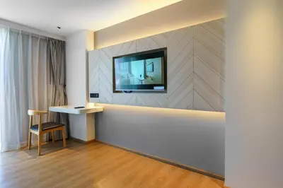 a living room with a television on a wall at Lovely studio 5 stars Hotel La Vita in Phuket Town
