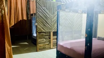 a room with two bunk beds and a window at Nu Bamboo Backpacker in Phuket