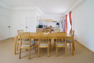 a dining room with a wooden table and chairs at 4BR Pool Villa Sukhum in Phuket Town in Changwat Phuket