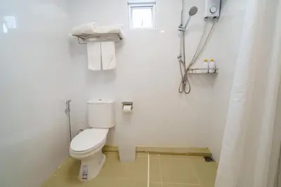 a white bathroom with a toilet and a shower at 4BR Pool Villa Sukhum in Phuket Town in Changwat Phuket