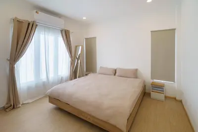a bedroom with a large bed and a large window at 4BR Pool Villa Sukhum in Phuket Town in Changwat Phuket