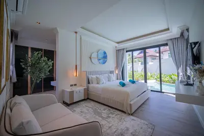 a bedroom with a bed and a couch and a window at Fifth Element Pool Villas by NLA in Bang Tao Beach