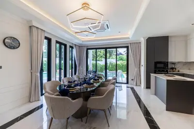 a dining room with a long table and chairs at Fifth Element Pool Villas by NLA in Bang Tao Beach