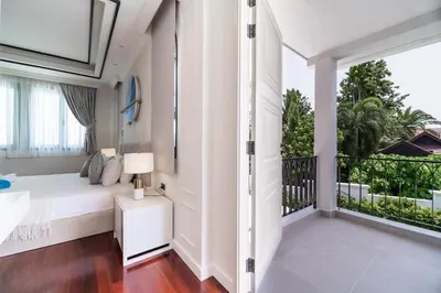 a bedroom with a bed and a balcony at Fifth Element Pool Villas by NLA in Bang Tao Beach