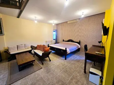 a bedroom with a bed and a couch and a table at Baibon3 Homestay Thalang Phuket in Ban Na Nai
