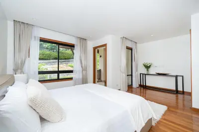 a white bedroom with a large bed and a window at Angsana Laguna Phuket 2- bedroom, with pool access in Layan Beach