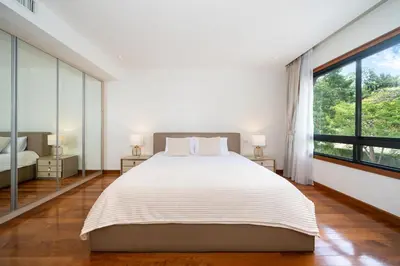 a bedroom with a large bed and a large window at Angsana Laguna Phuket 2- bedroom, with pool access in Layan Beach