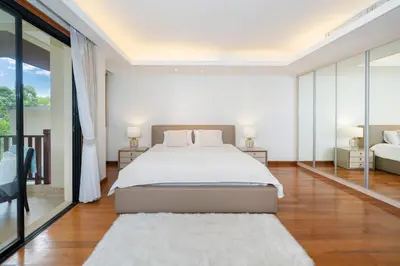a white bedroom with a bed and a large window at Angsana Laguna Phuket 2- bedroom, with pool access in Layan Beach
