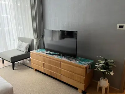a living room with a tv and a chair at Baan Mai Khao Condo Phuket for rent in Phuket