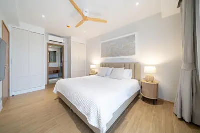 a bedroom with a white bed and two lamps at Laguna Beachside Residents in Phuket