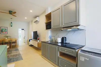 a kitchen with stainless steel appliances and a living room at Winks Beach Patong Phuket in Patong Beach