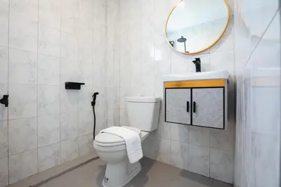a bathroom with a toilet and a sink and a mirror at Winks Beach Patong Phuket in Patong Beach