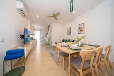 a dining room and living room with a table and chairs at Winks Beach Patong Phuket in Patong Beach