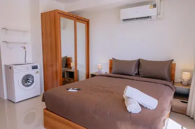 a bedroom with a bed and a washing machine at 1 BR studio 777 Beach Condotel in Mai Khao Beach