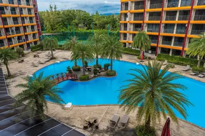 an overhead view of the pool at a resort with palm trees at 1 BR studio 777 Beach Condotel in Mai Khao Beach