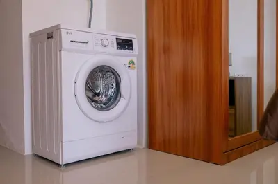 a white washing machine sitting next to a wooden door at 1 BR studio 777 Beach Condotel in Mai Khao Beach
