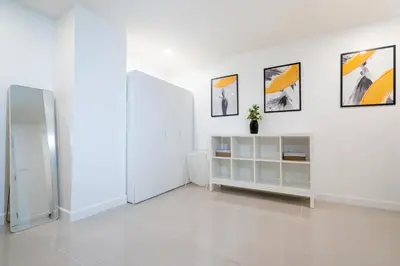 a white room with three pictures on the wall at Winks House Patong Phuket 4B in Patong Beach