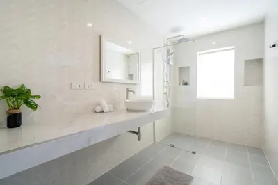 a white bathroom with a sink and a mirror at Winks House Patong Phuket 4B in Patong Beach