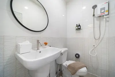 a bathroom with a sink and a toilet and a mirror at 4BR villa W Jacuzzi Heart of Patong in Patong Beach