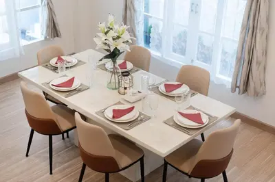 a white dining room table with chairs and a vase of flowers at 4BR villa W Jacuzzi Heart of Patong in Patong Beach
