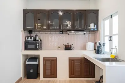 a kitchen with brown cabinets and a sink at 4BR villa W Jacuzzi Heart of Patong in Patong Beach