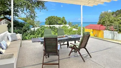 a patio with a table and chairs and the ocean at At the Beach New 6-9 person Pool Villa Ao Yon Phuket in Ko Thanan