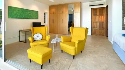 a bedroom with two yellow chairs and a bed at At the Beach New 6-9 person Pool Villa Ao Yon Phuket in Ko Thanan