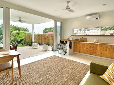an open kitchen and living room with sliding glass doors at At the Beach New 6-9 person Pool Villa Ao Yon Phuket in Ko Thanan
