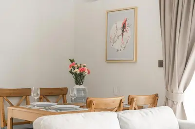 a dining room with a table with a vase of flowers at Title Halo 1st Floor Naiyang Pool Gym 2BR in Nai Yang Beach