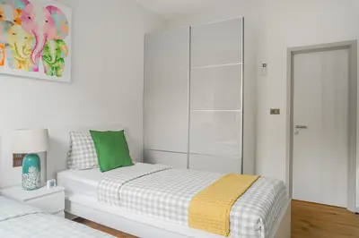 a white bedroom with a bed and a glass closet at Title Halo 1st Floor Naiyang Pool Gym 2BR in Nai Yang Beach