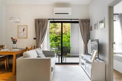 a living room with a couch and a table at Title Halo 1st Floor Naiyang Pool Gym 2BR in Nai Yang Beach