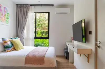 a bedroom with a bed and a tv and a window at Title Halo 1st Floor Naiyang Pool Gym 2BR in Nai Yang Beach