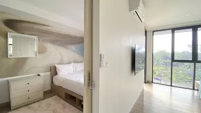a bedroom with a bed with a painting on the wall at 1BDR Laguna 10 min to the Sea Roof Pool in Laguna Phuket