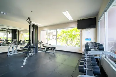 a gym with treadmills and chairs and a large window at \u82ad\u4e1c 19243 \u4e24\u5367\u6cf3\u6c60\u516c\u5bd3 \u8fd1Bangla \u73ed\u8d5e\u591c\u5e02 \u6c5f\u897f\u51b7\u8d2d\u7269\u5546\u573a in Patong Beach