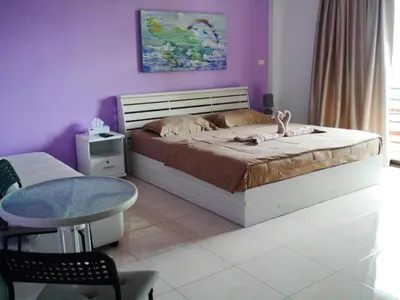 a bedroom with a bed with a purple wall at Da Puccio Rawai Guesthouse in Rawai Beach