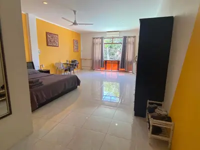 a bedroom with a bed and a room with a table at Da Puccio Rawai Guesthouse in Rawai Beach