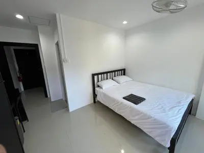 a white bedroom with a bed with white sheets and pillows at Patong Easy life 5 in Patong Beach