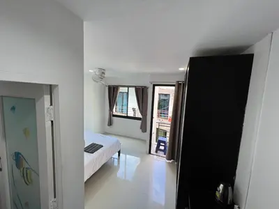 a bedroom with a bed and two windows at Patong Easy life 5 in Patong Beach