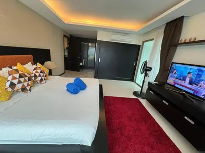 a bedroom with a large bed and a flat screen tv at Modern 2-Bedroom Condo in Kamala Near the beach in Kamala Beach