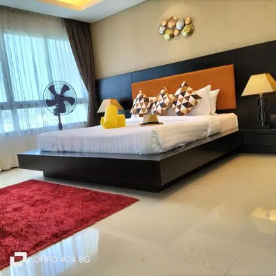 a bedroom with a large bed with a red rug at Modern 2-Bedroom Condo in Kamala Near the beach in Kamala Beach